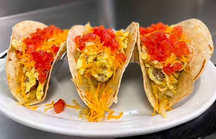 Three breakfast tacos with egg, cheddar and salsa